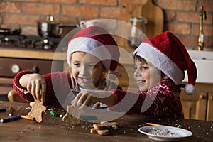 Happy adorable little children sibling playing with Christmas gingerbreads.