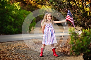 Happy adorable little girl smiling and waving American flag outs