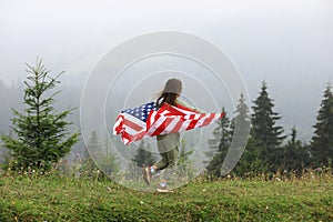 Happy adorable little girl smiling and waving American flag. Patriotic holiday. Happy kid, cute little child girl with American