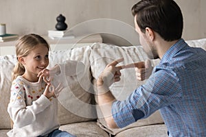 Happy adorable small kid using sign language, communicating with father.