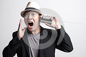 Happy Adult Asian man  listen with tin can phone