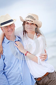 Happy adult couple in summertime on beach