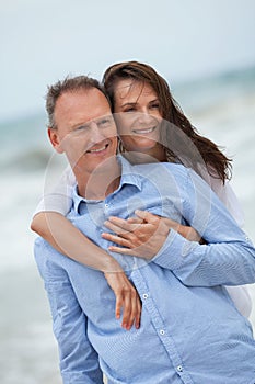 Happy adult couple in summertime on beach