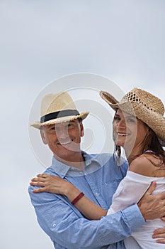 Happy adult couple in summertime on beach