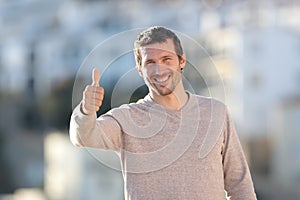 Happy adult man gesturing thumbs up in a rural town