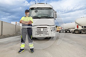 Happy adult man mechanic standing near parked truck