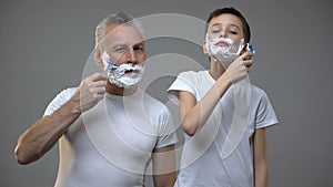 Happy adult man and preteen boy shaving, kid teaching to be man, morning ritual