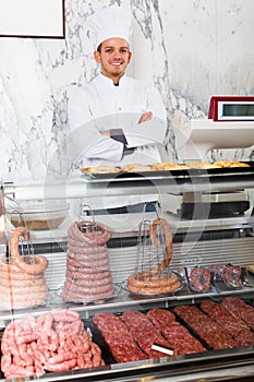 Happy adult man seller working at meat market