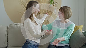 Happy adult mother and daughter embracing. Senior mother and lovely daughter relax on the sofa