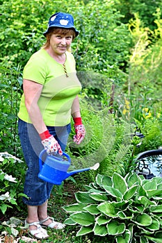 Happy adult woman gardener care for plants