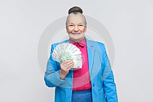 Happy adult woman holding many euro