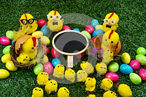 Happy aester hatching chickens on a grass background, with glasses in a nest, on a yellow background with place for inscription