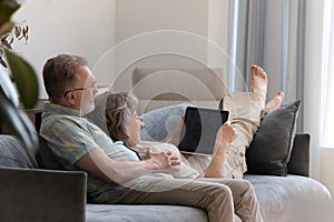 Happy middle aged couple using laptop at home.