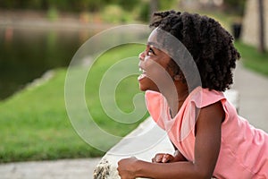 Happy African Amerian little girl smiling outside.