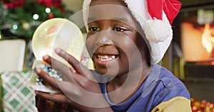 Happy african american boy with snow globe