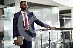 Happy african american businessman with laptop at offce building