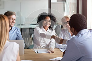 Happy african american colleagues partners handshake at team corporate meeting