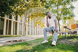 Happy african american college student teenager having a funny call conversation and laughing. Portrait of a young guy