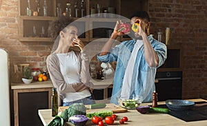 Happy african-american couple cooking and having fun in kitchen