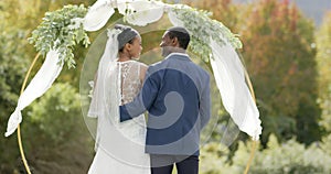 Happy african american couple embracing at their wedding ceremony in sunny garden, in slow motion