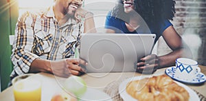 Happy african american couple are having breakfast together in the morning at the wooden table.Smiling black man and his