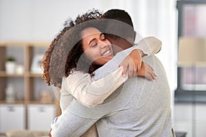 Happy african american couple hugging at home photo