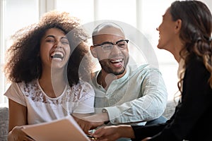 Happy African American couple laughing at meeting with realtor