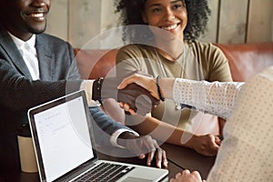 Happy african american couple making deal handshaking caucasian