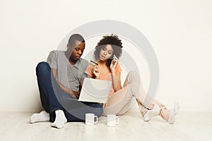 Happy african-american couple shopping online on laptop