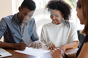 Happy African American couple signing contract, making deal