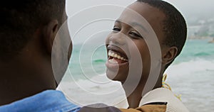 Happy African american couple standing together o the beach 4k