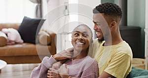 Happy african american couple talking and hugging on sofa