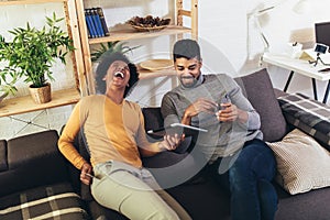 Happy african-american couple using digital tablet, shopping at food delivery on sofa at new apartment, copy space