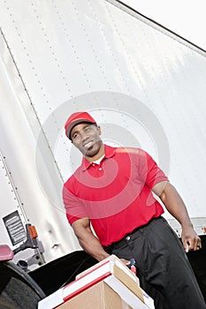 Happy African American delivery man pushing handtruck photo