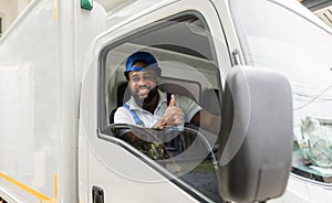 Happy African American delivery service man driver in uniform sitting smiling and thumb up with looking on camera cheerful in a