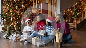 Happy African American family celebrating Christmas, holding gifts