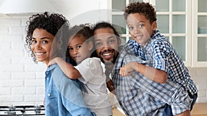 Happy African American family couple holding little sibling kids