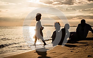 Happy African American family, father, mother and daughters happiness vacation relax with sea background.Parents with children