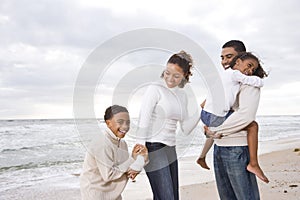 Happy African-American family of four on beach