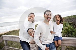 Happy African-American family of four on beach