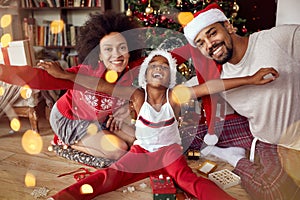 Happy African American family in front of Christmas tree