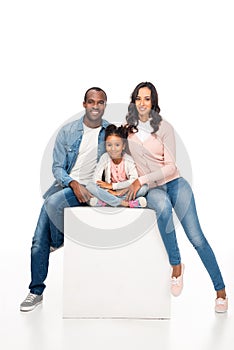 happy african american family with one child sitting together and smiling at camera