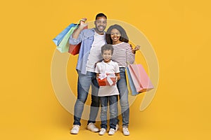 Happy african american family holding gift and colorful shopping bags