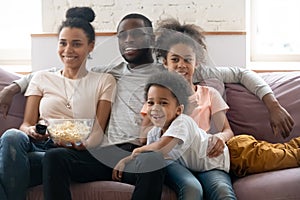 Happy african american family with kids watching funny tv show.