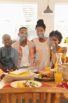Happy African American family looking at camera on dining table