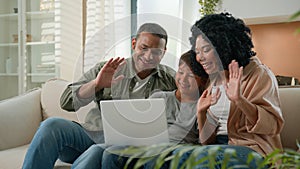 Happy African American family mom dad and teen son use laptop webcam distance video call multiracial parents little boy