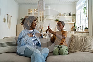 Happy African American family mom and son celebrating Mothers Day together at home