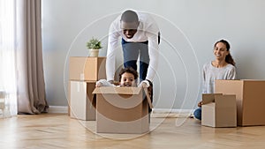 Happy African American family moving, having fun in new apartment