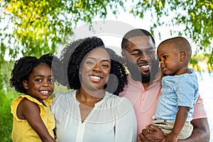 Happy African American family outside at a park.