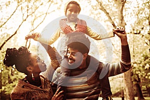 Happy African American family in park together.